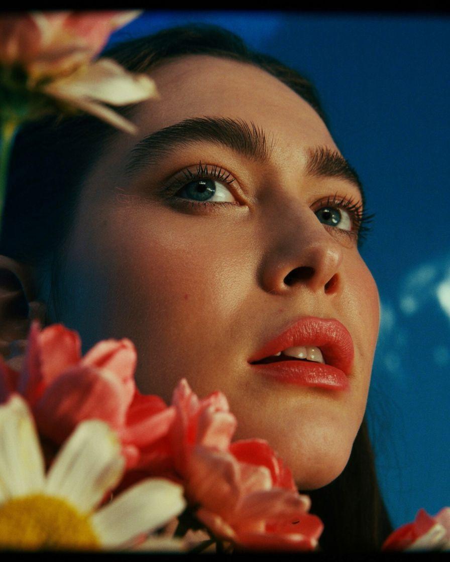 a close up of a woman with flowers in her hair