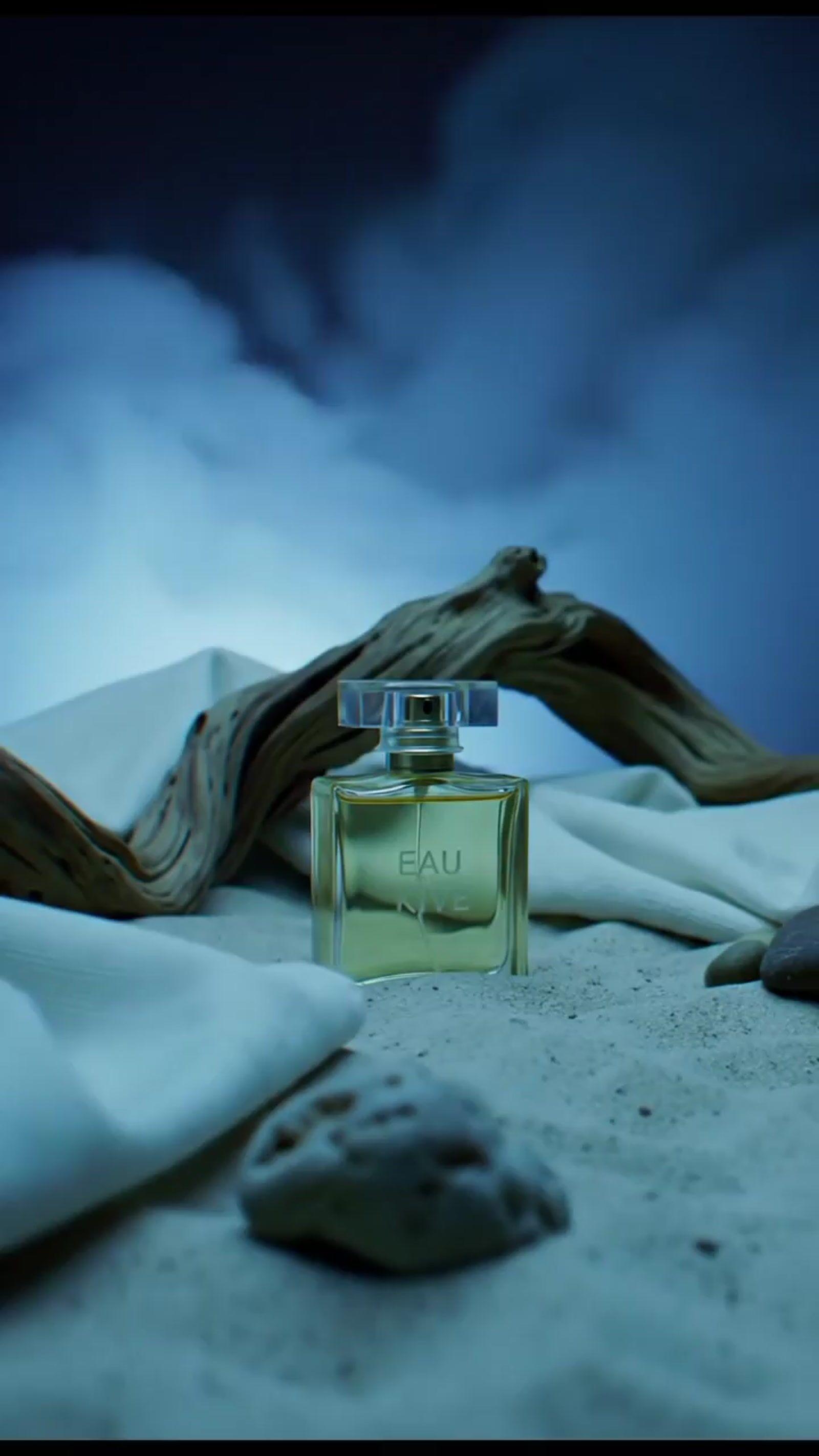 a bottle of perfume sitting on top of a bed