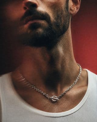 a man wearing a necklace with a cross on it