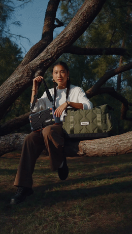 a woman sitting on a tree branch holding a camera