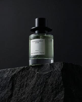 a bottle of perfume sitting on top of a rock