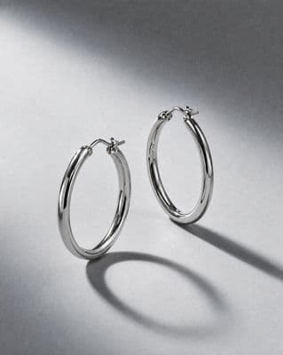 a pair of silver hoop earrings on a white background