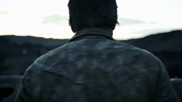 a man standing in front of a mountain with a cell phone in his hand