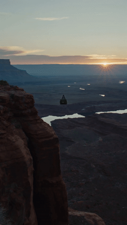 a person standing on a cliff overlooking a lake