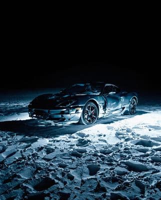 a sports car is parked in the snow