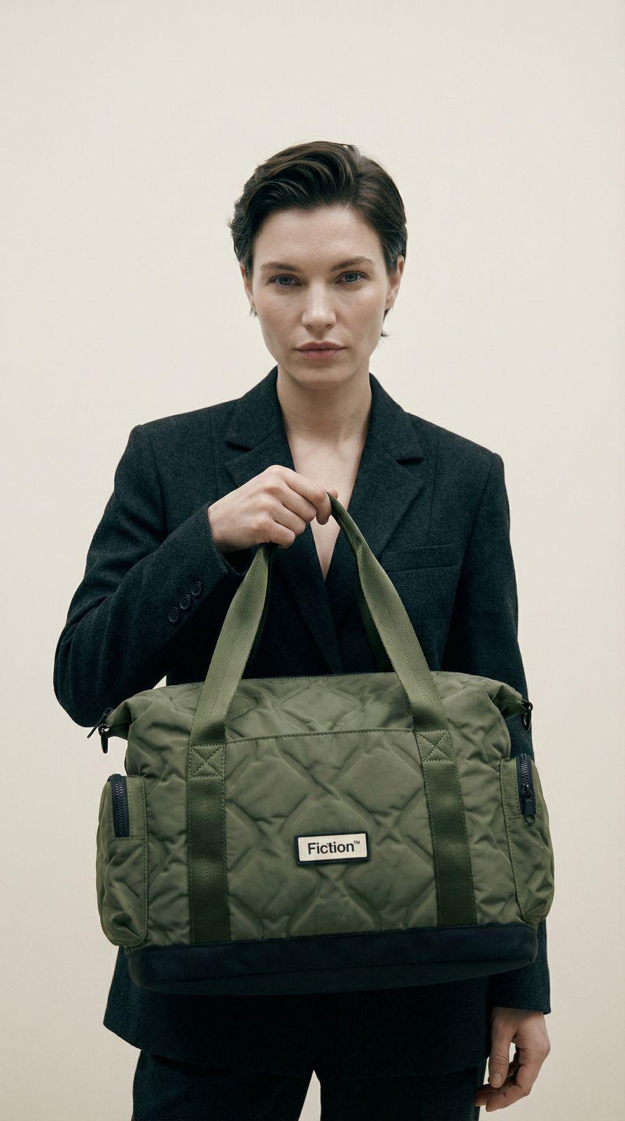 a woman holding a green duffel bag