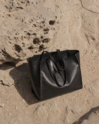 a black bag sitting on top of a sandy beach
