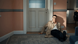 a man sitting on the floor in front of a door