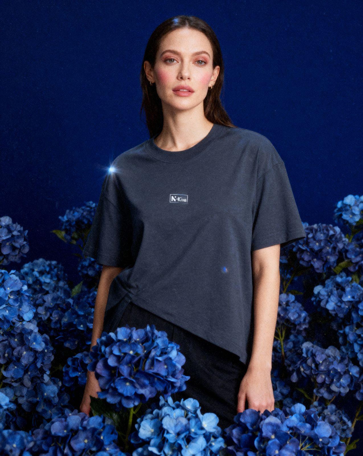 a woman standing in a field of blue flowers
