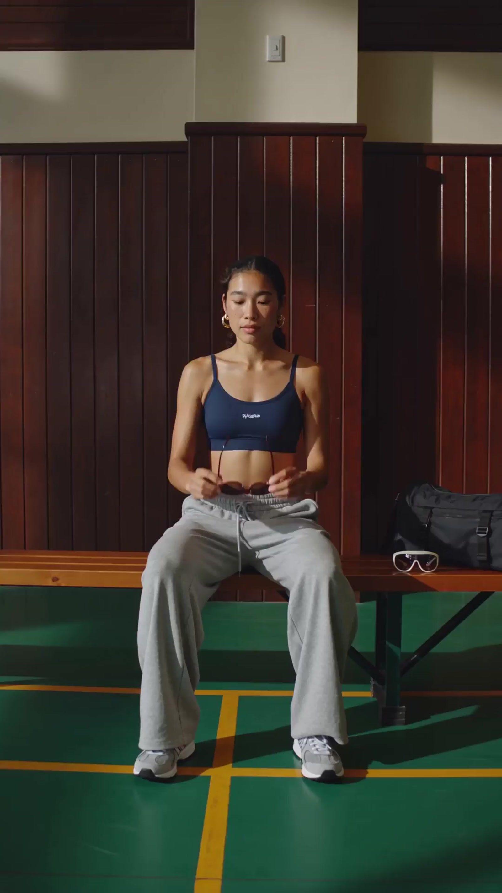 a woman sitting on a bench in a gym