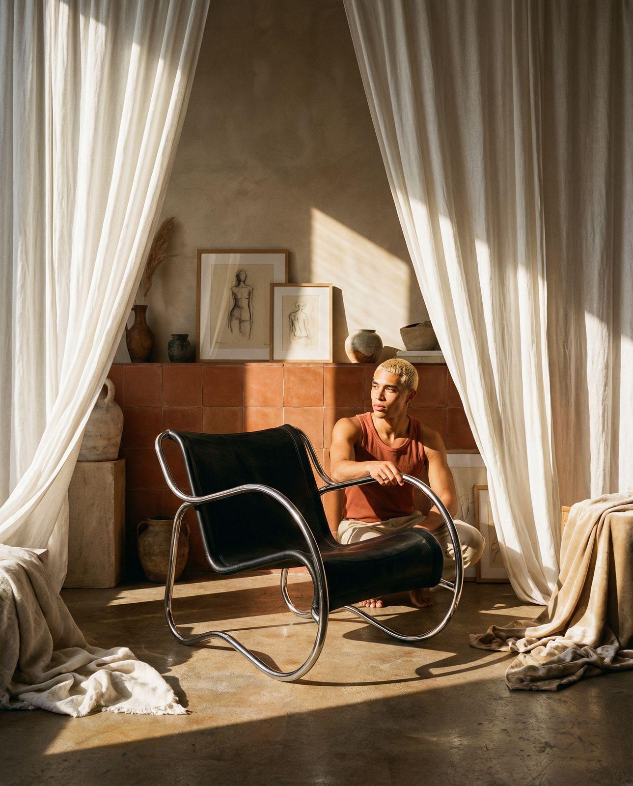 a man sitting in a chair in front of a window