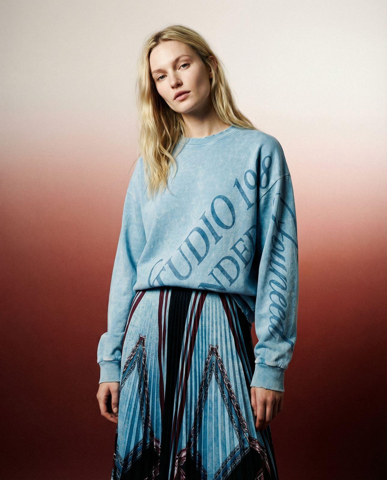 a woman in a blue sweater and skirt