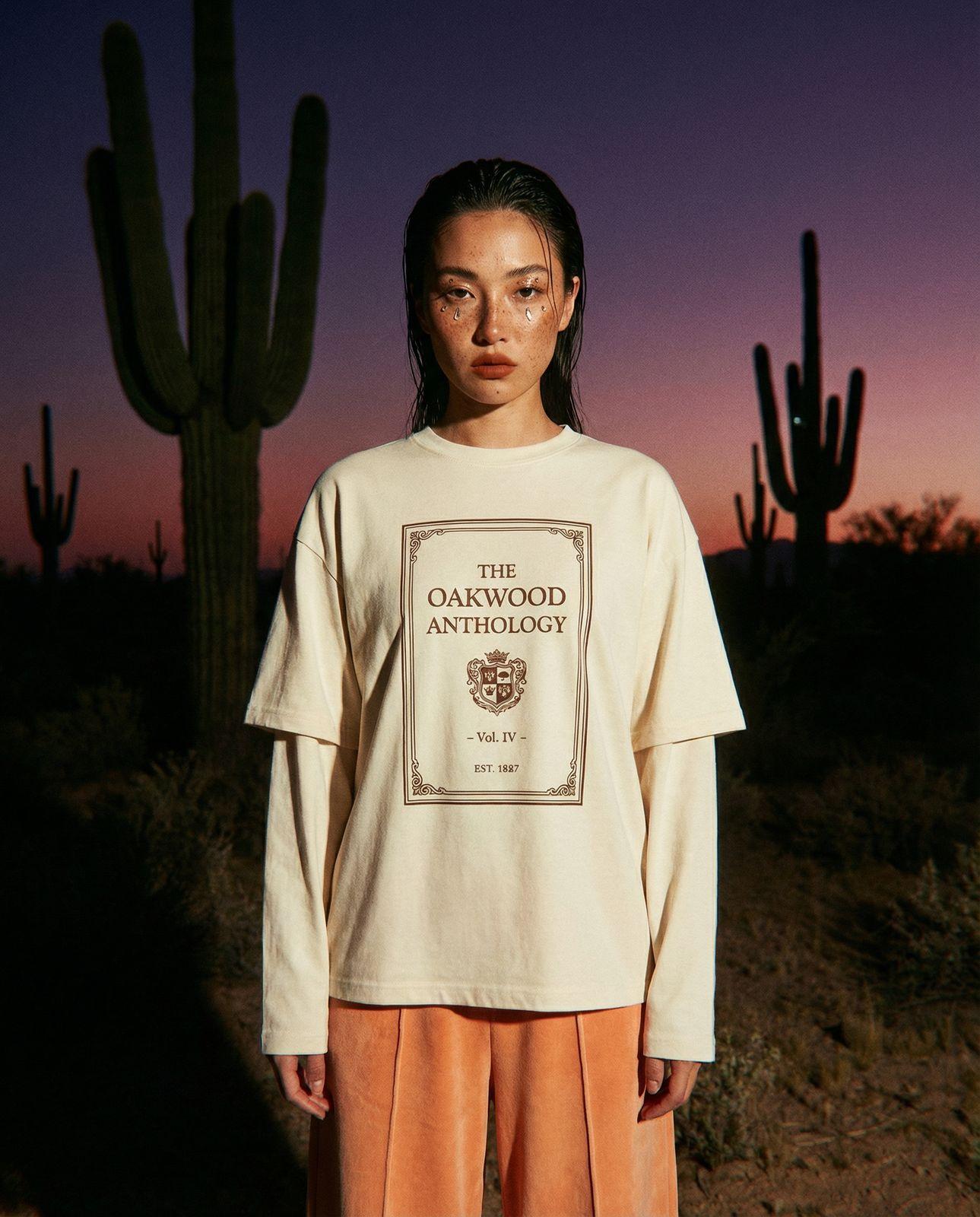 a woman standing in front of a cactus