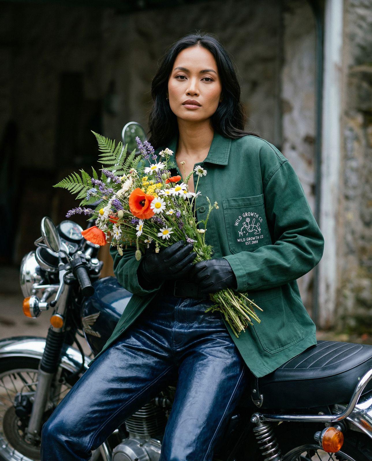 a woman sitting on a motorcycle holding a bunch of flowers