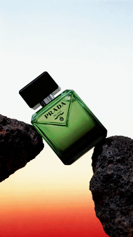 a bottle of perfume sitting on top of a rock