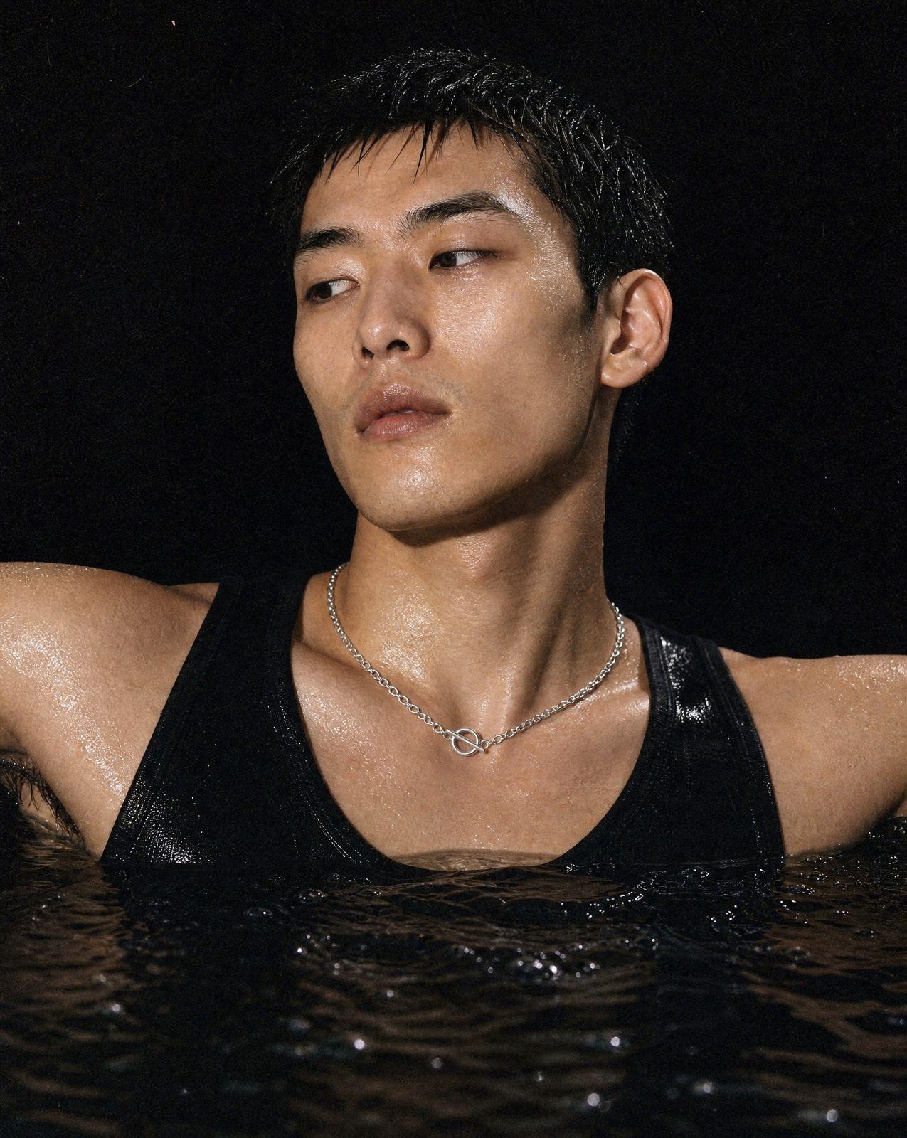 a man wearing a black tank top in a body of water