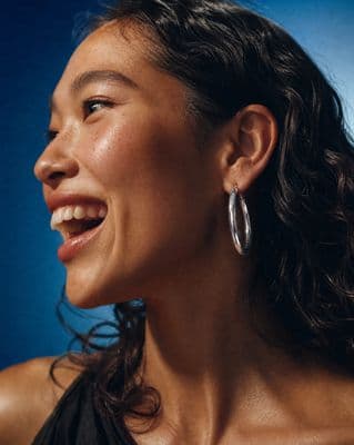a close up of a person wearing a pair of earrings
