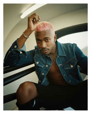 a man with a pink mohawk sitting down