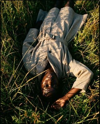 a person laying on the ground in the grass