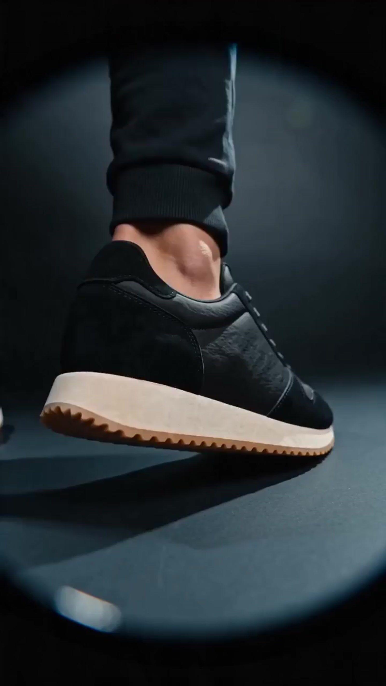 a person's feet in a pair of black sneakers