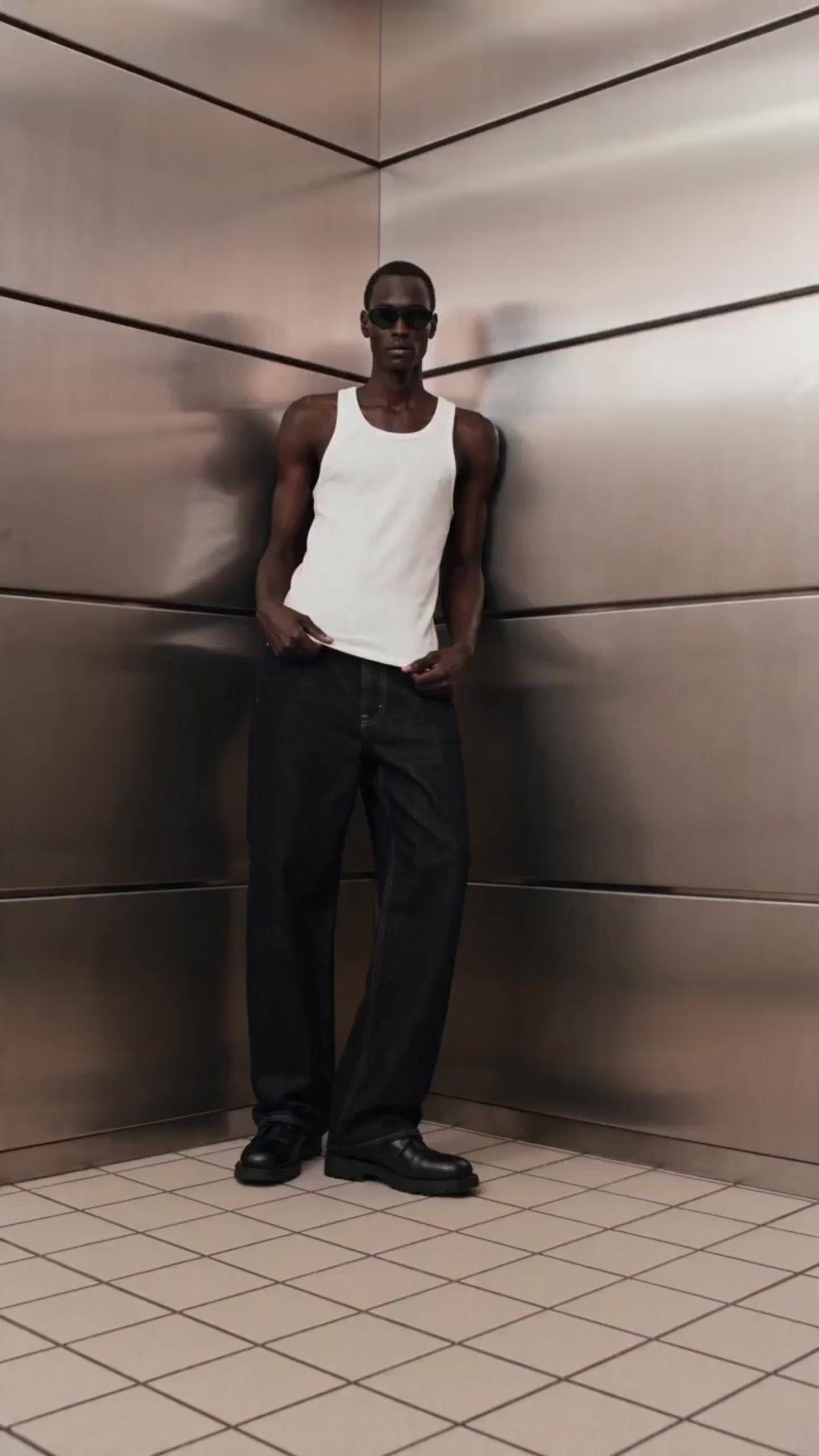 a man standing in front of a metal wall