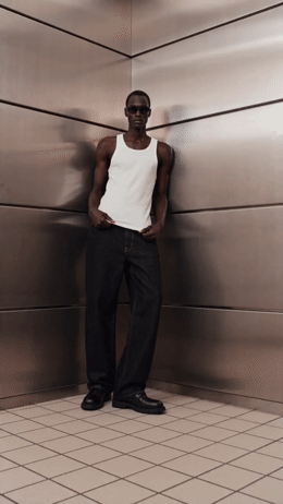 a man standing in front of a metal wall
