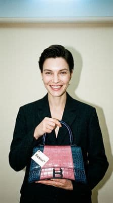 a woman holding a purse with a name tag on it