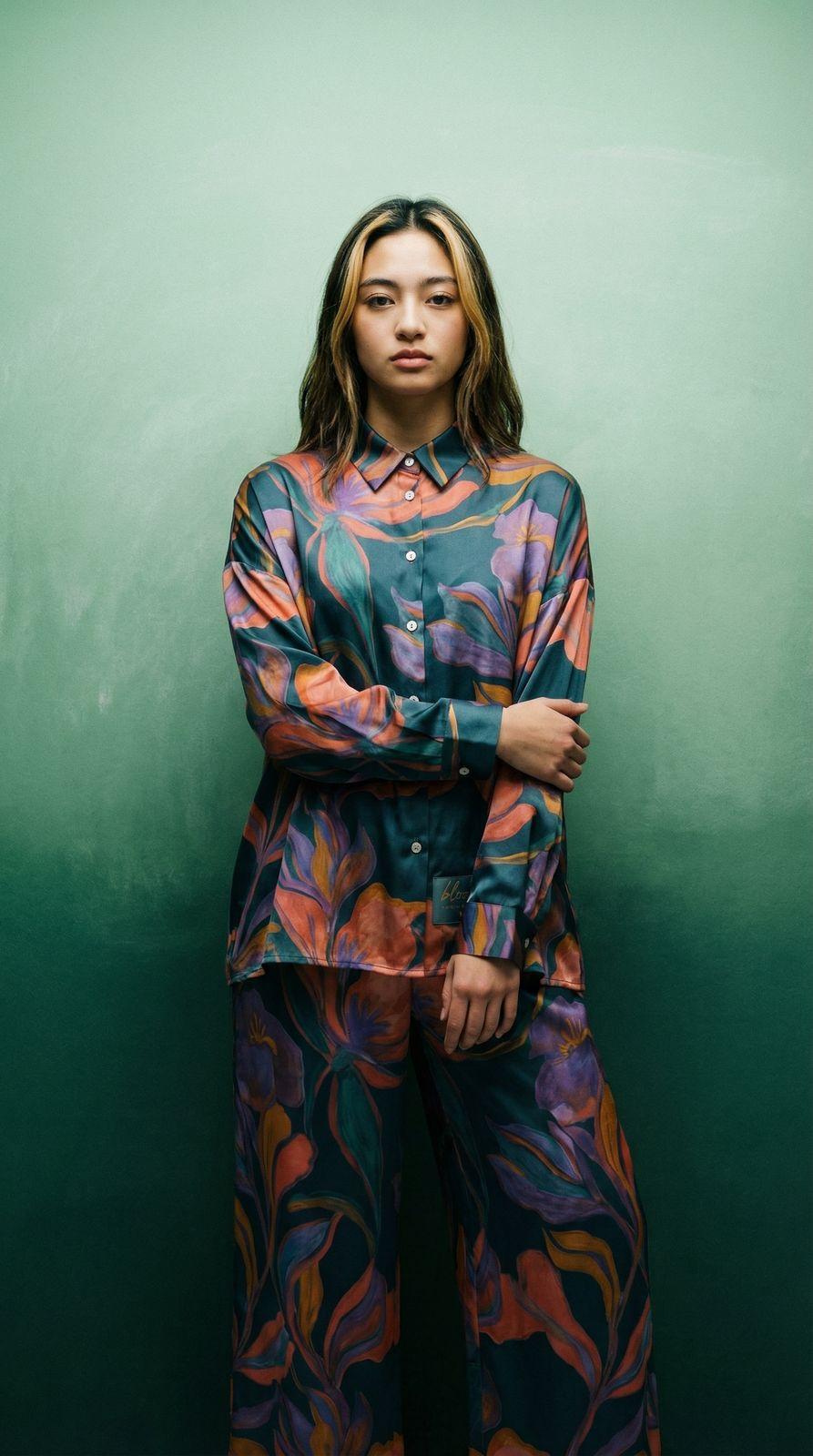 a woman standing in front of a green wall