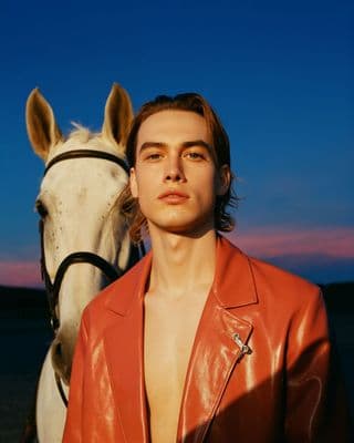 a man standing next to a white horse
