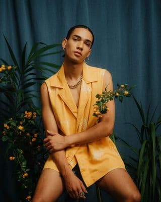 a man sitting on a chair in front of a plant
