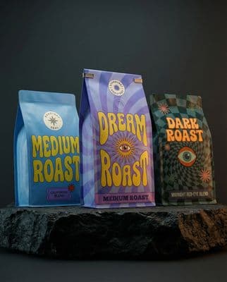 three bags of coffee sitting on top of a rock