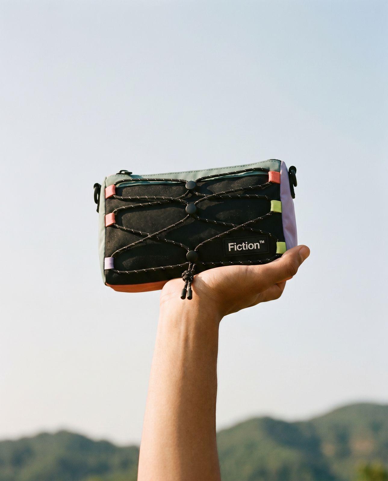 a hand holding a black piece of luggage