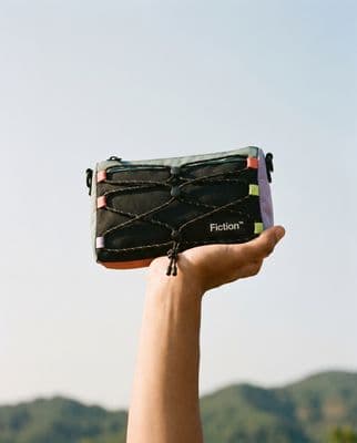 a hand holding a black piece of luggage