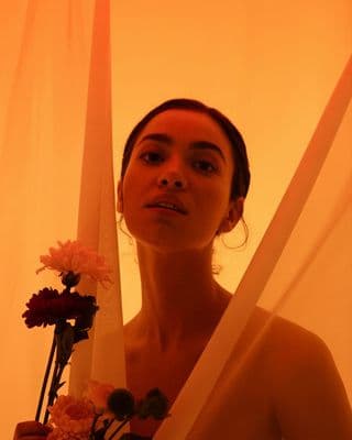 a woman holding a bouquet of flowers in front of her face