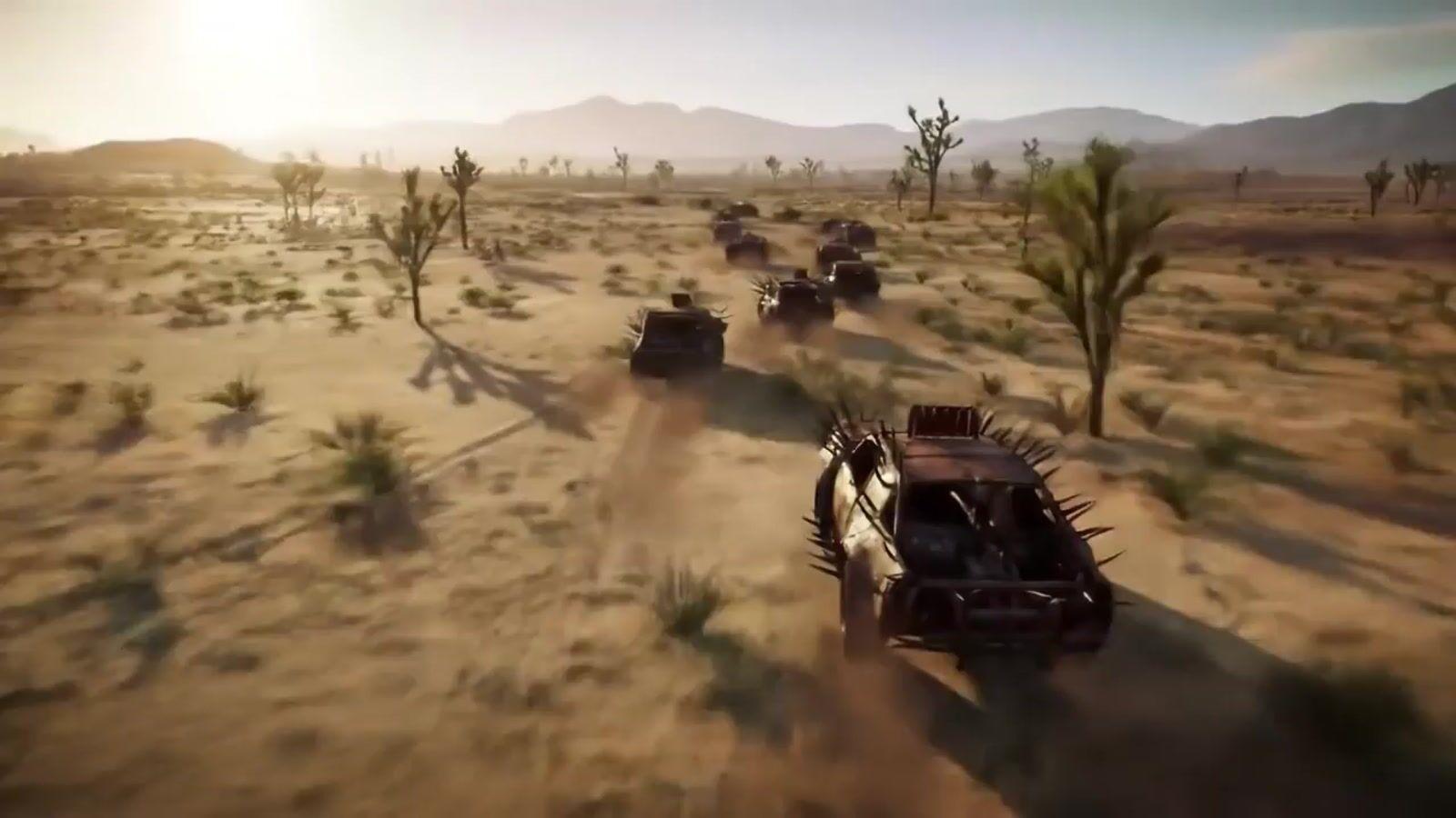 a group of four vehicles driving through a desert