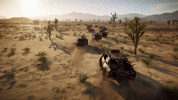 a group of four vehicles driving through a desert
