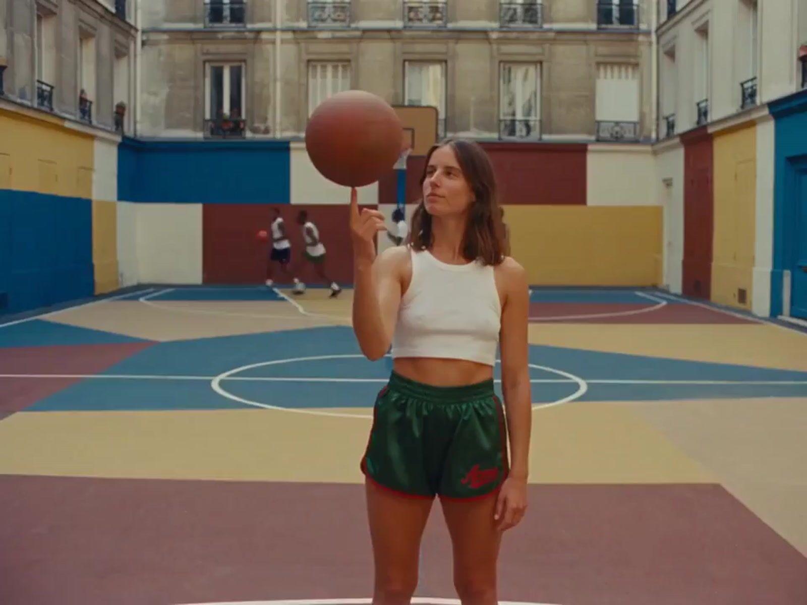 a woman holding a basketball while standing on a basketball court