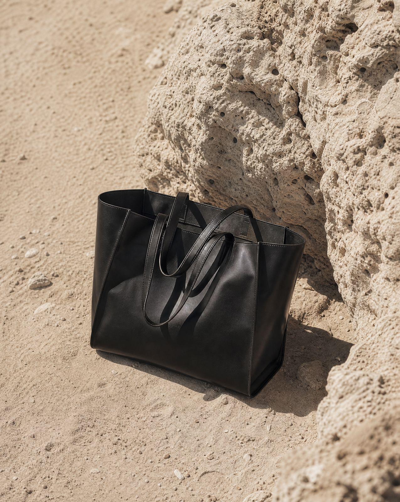 a black bag sitting on top of a sandy beach