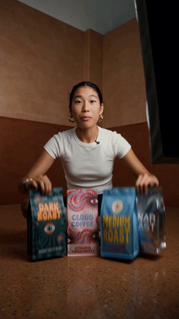 a woman sitting on the floor holding three bags of food