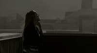 a woman standing on a balcony talking on a cell phone