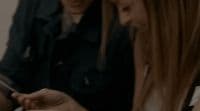 two girls looking at a cell phone together