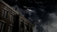 a man standing on top of a building under a cloudy sky