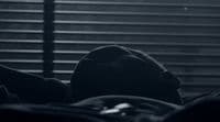 a black and white photo of a person laying in bed