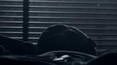 a black and white photo of a person laying in bed