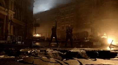 a group of people standing on a street next to a fire