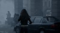 a woman walking down a street next to a car