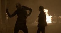 a couple of people standing in front of a fire