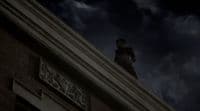 a man standing on top of a building under a cloudy sky