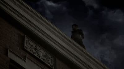 a man standing on top of a building under a cloudy sky