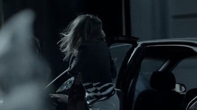 a woman getting out of a car at night